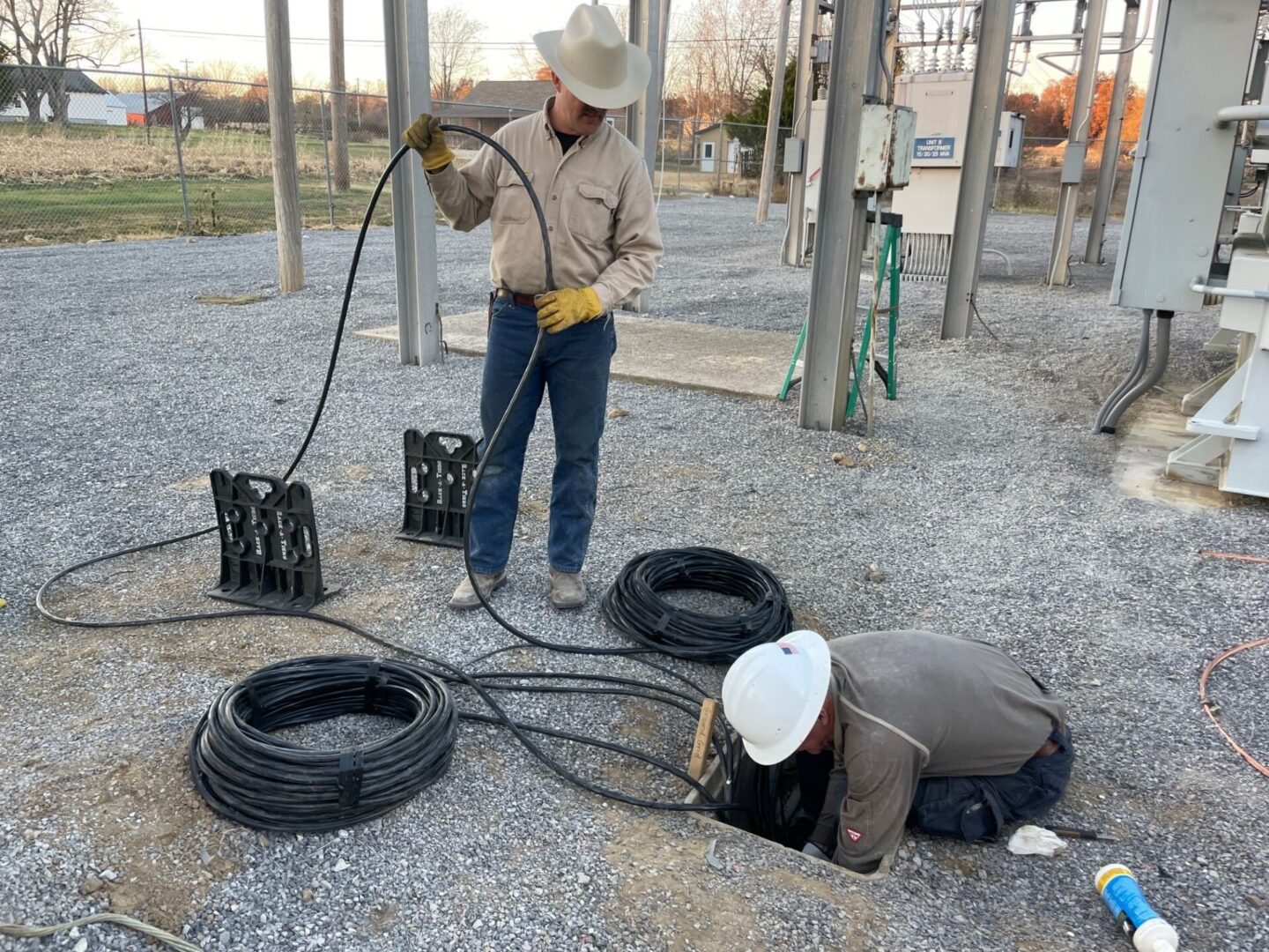 A man in cowboy hat and boots holding a hose.