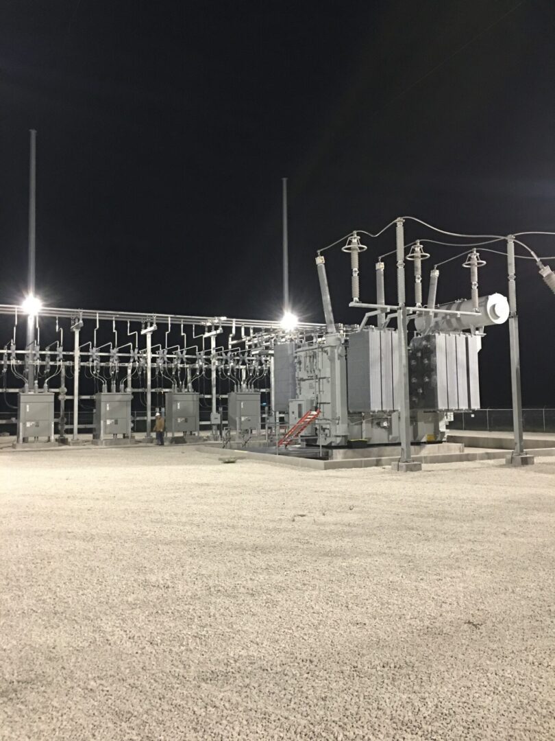 A power plant with many electrical equipment on the ground.