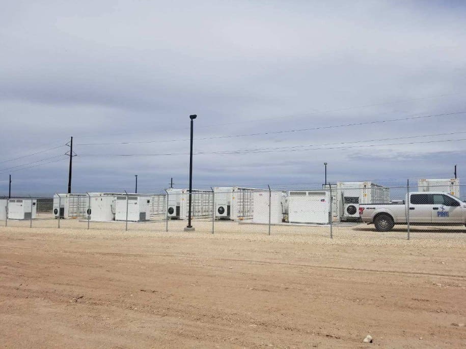 A truck parked in front of a row of storage containers.